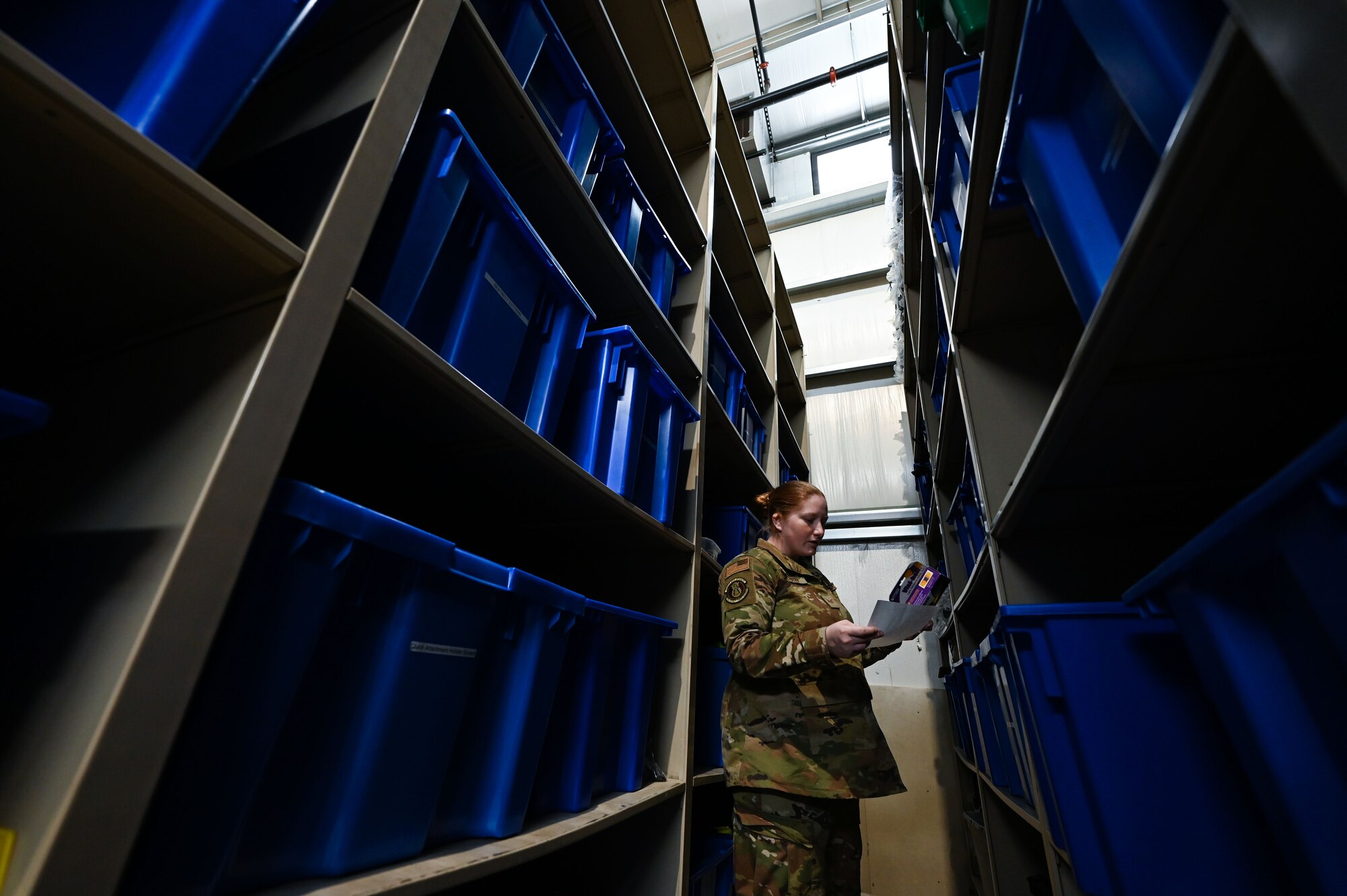 Airman stands in warehouse.