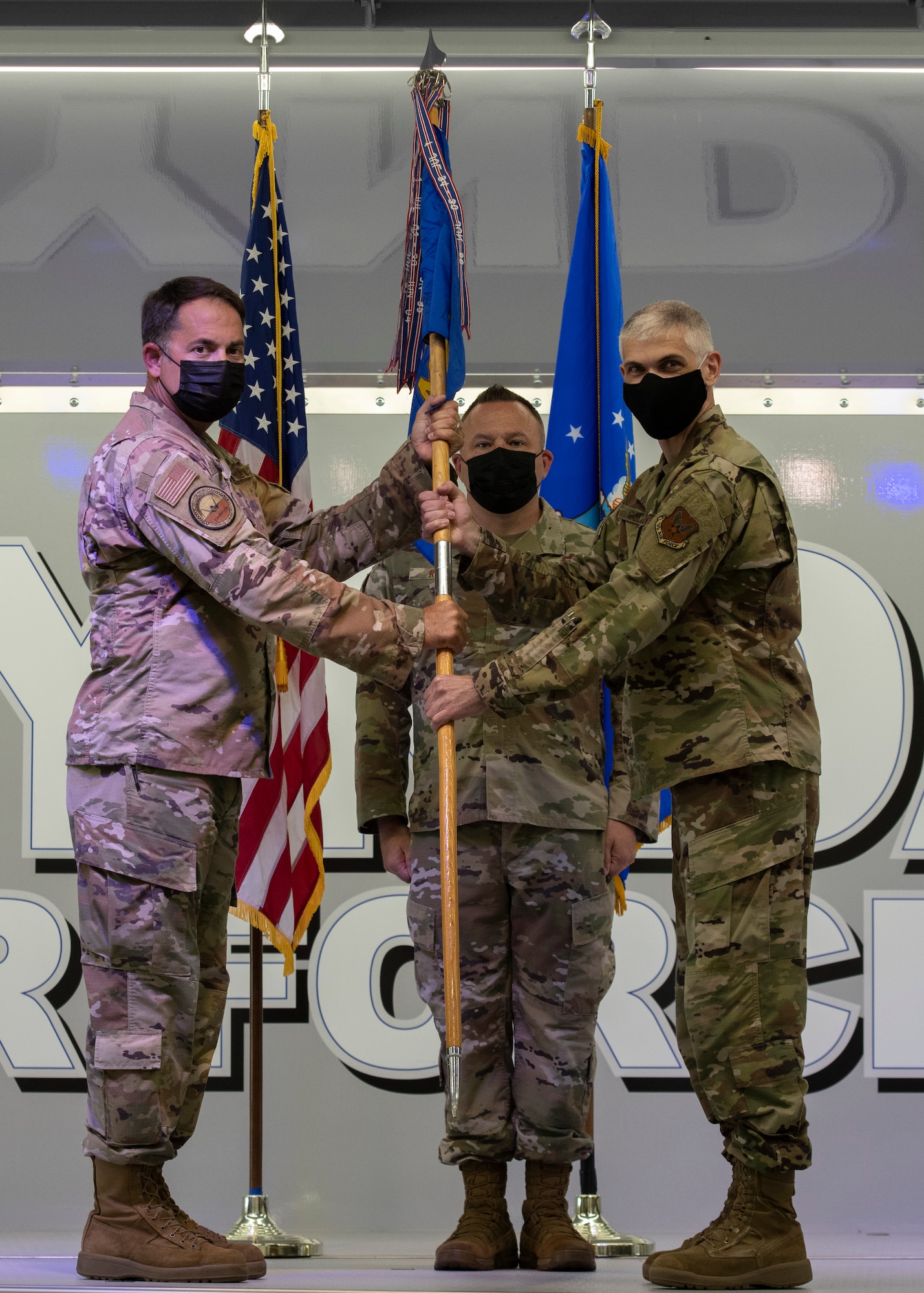U.S. Air Force Col. Greg Moseley, 325th Fighter Wing commander, left, passes the guidon  to Col. Steven Collen, 325th Maintenance Group commander, right, during an assumption of command ceremony at Tyndall Air Force Base, Florida, May 11, 2021.