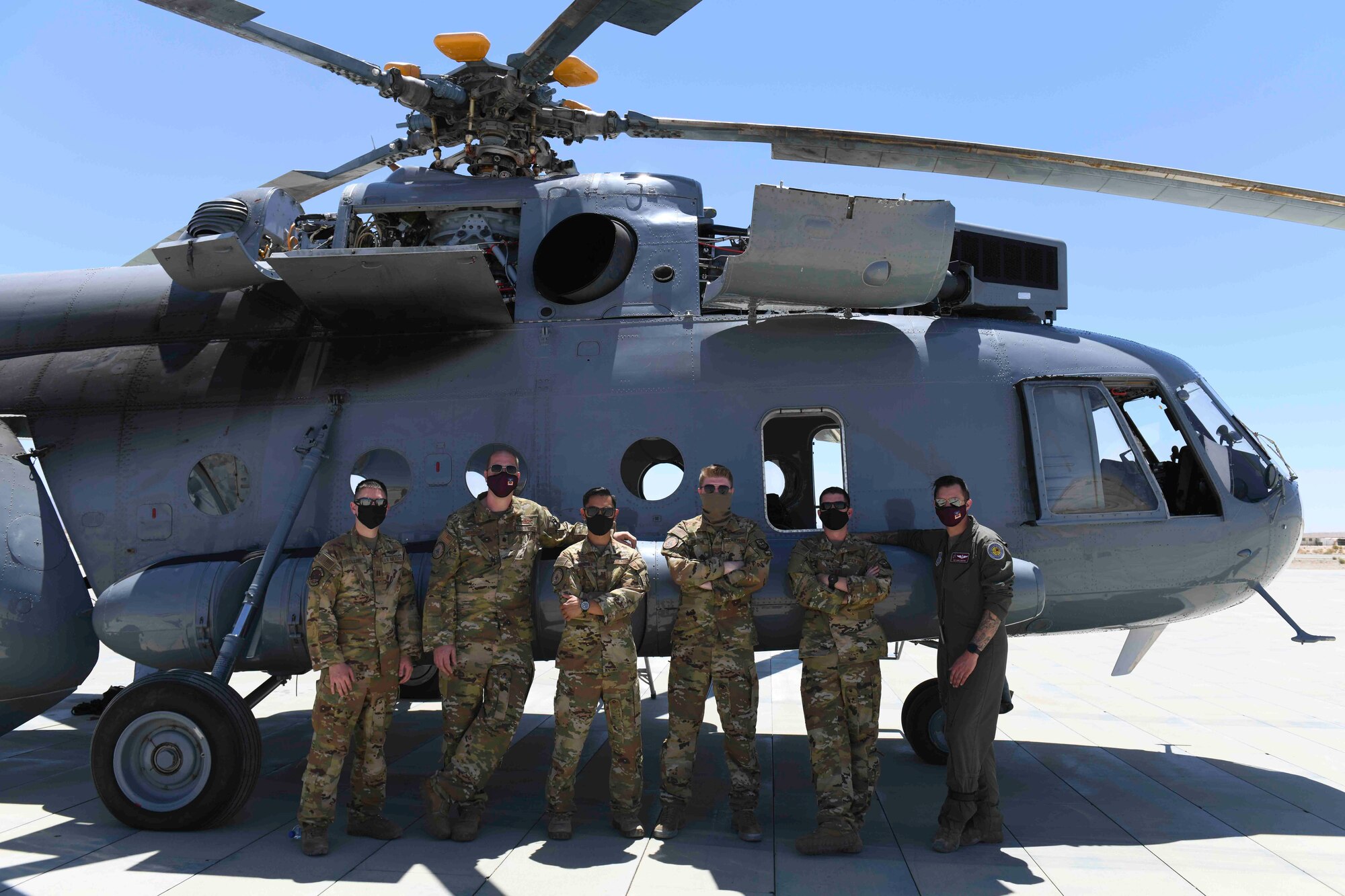 Team Fairchild Airmen from the 384th and 93rd Air Refueling Squadrons pose in front of a Mil Mi-17 helicopter after flying over the Marine Corps Air Ground Combat Center, May 6, 2021. The observation allowed Team Fairchild the opportunity to create a joint partnership between Airmen and Marines for future exercises. (U.S. Air Force photo by Airman 1st Class Kiaundra Miller)