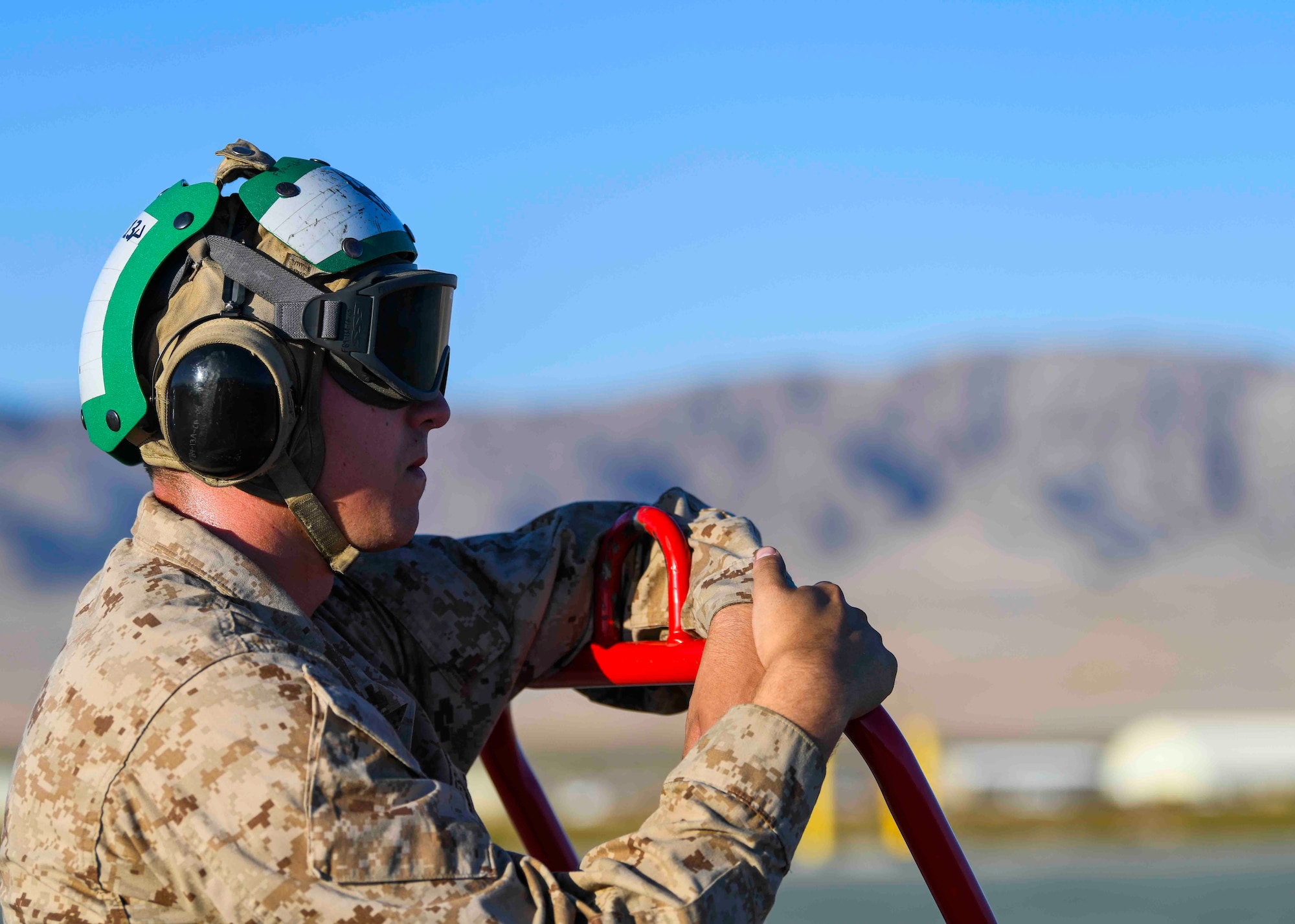 A U.S. Marine observes a hot pit refueling on the Marine Corps Air Ground Combat Center airfield, California, May 4, 2021. The observation allowed Team Fairchild the opportunity to create a joint partnership between Airmen and Marines for future exercises. (U.S. Air Force photo by Airman 1st Class Kiaundra Miller)