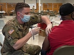 A Virginia National Guard Soldier administers a COVID-19 vaccine to a citizen during a mobile vaccination clinic in Norfolk, Virginia.