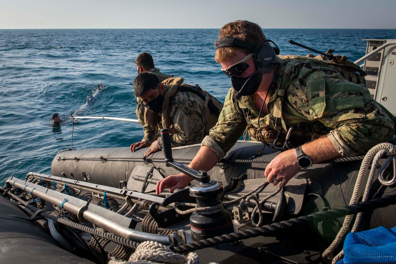 Sailors work on a small boat.