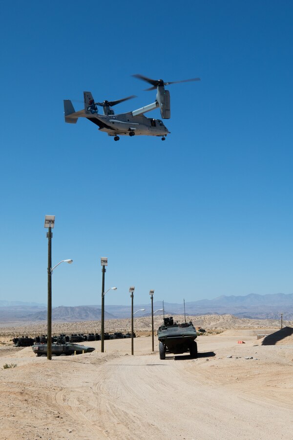 U.S. Marines with Company D, 3rd Assault Assault Battalion, 1st Marine Division, provide security for infantry Marines while an MV-22 osprey flies overhead during an integrated training exercise at Marine Corps Air Ground Combat Center Twentynine Palms, California, April 7, 2021. These Marines conducted an urban terrain training simulation to improve capabilities between infantry units and combat support units. (U.S. Marine Corps photo by Cpl. Jamin M. Powell)
