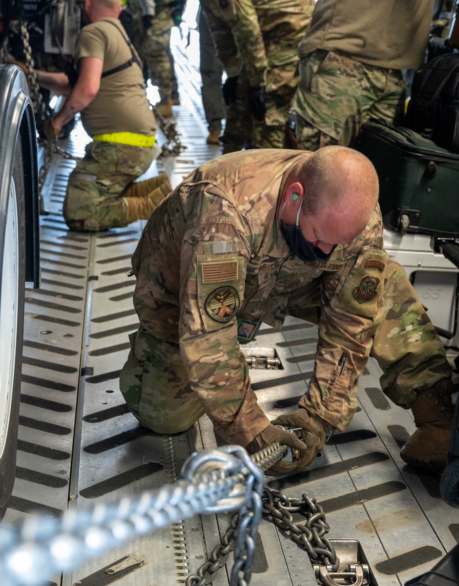 Tech Sgt. Ryan Price, 436th Aerial Port Squadron ramp services specialist, chains an Analytical Laboratory System to the floor of a C-17 Globemaster III at Dover Air Force Base, Delaware, May 13, 2021. Service members from 31st Civil Support Team, Delaware National Guard, participated in the first ALS airlift mission heading to Boulder Regional Training Center located in Boulder, Colorado. The ALS consists of multiple variants of laboratories, enabling operators to test on-site for chemical, radiological, biological and nuclear threats. (U.S. Air Force photo by Airman 1st Class Faith Schaefer)