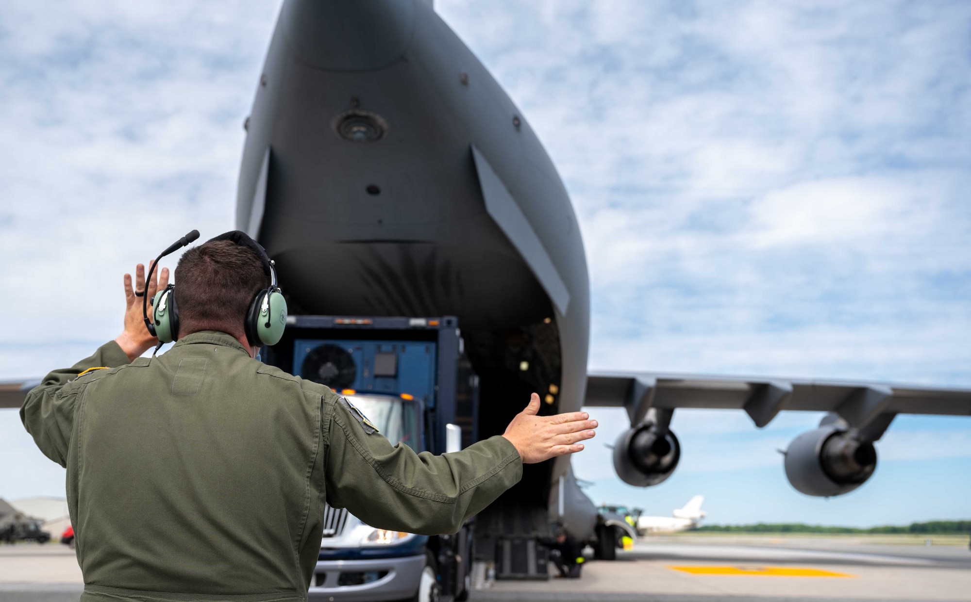 Tech. Sgt. Justin Peters, 156th Airlift Squadron loadmaster, marshals a mobile Analytical Laboratory System onto a C-17 Globemaster III at Dover Air Force Base, Delaware, May 13, 2021. Service members from 31st Civil Support Team, Delaware National Guard, participated in the first ALS airlift mission heading to Boulder Regional Training Center located in Boulder, Colorado. The ALS consists of multiple variants of laboratories, enabling operators to test on-site for chemical, radiological, biological and nuclear threats. (U.S. Air Force photo by Airman 1st Class Faith Schaefer)