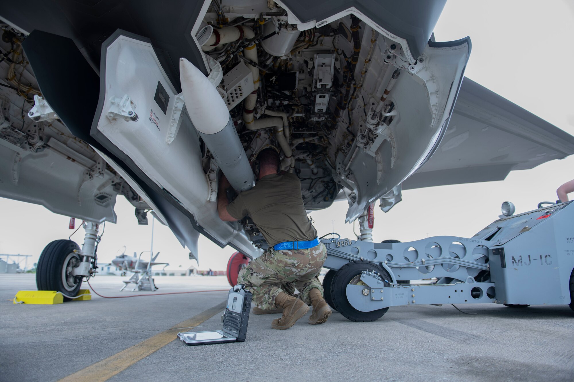 Man loading a missile onto an aircraft
