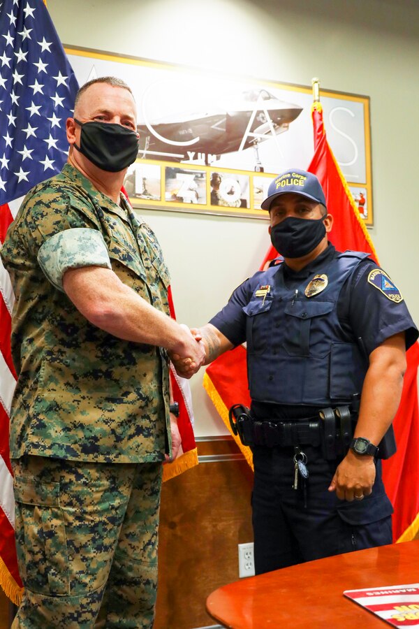 Col. Chuck Dudik and Military Police Officer Karl Bobbio shake hands after an award ceremony at Marine Corps Air Station (MCAS) Yuma, May 12, 2021.