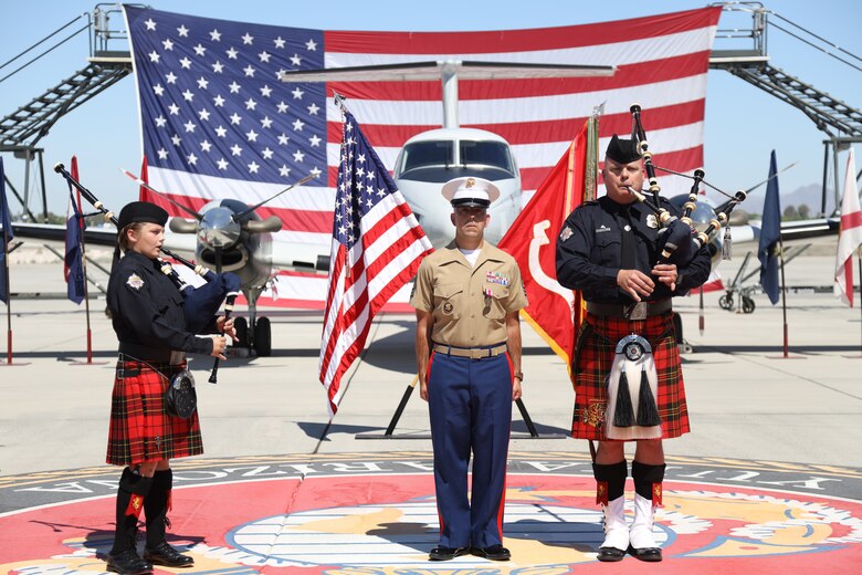 U.S. Marine Corps Master Sgt. Chris Medina stands at attention while two bagpipers play Anchors Away and the Marine Corps Hymn during a retirement ceremony at Marine Corps Air Station Yuma, April 30, 2021.  The ceremony honored MSgt Medina and the sacrifice he made while serving in the Marine Corps. (U.S. Marine Corps photo by LCpl. Matthew Romonoyske-Bean)
