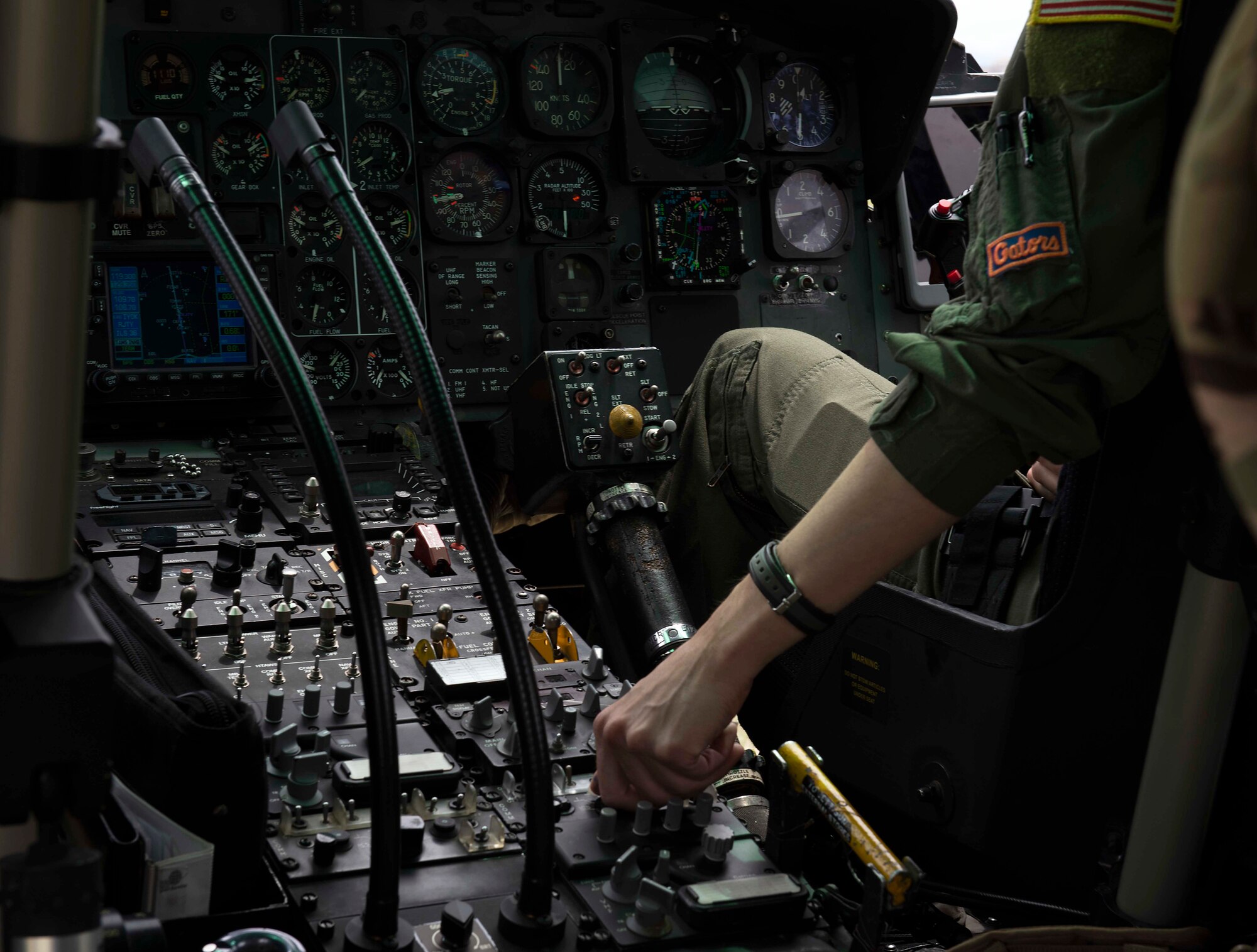 A U.S. Air Force pilot adjusts a UH-1N Iroquois helicopter’s controls