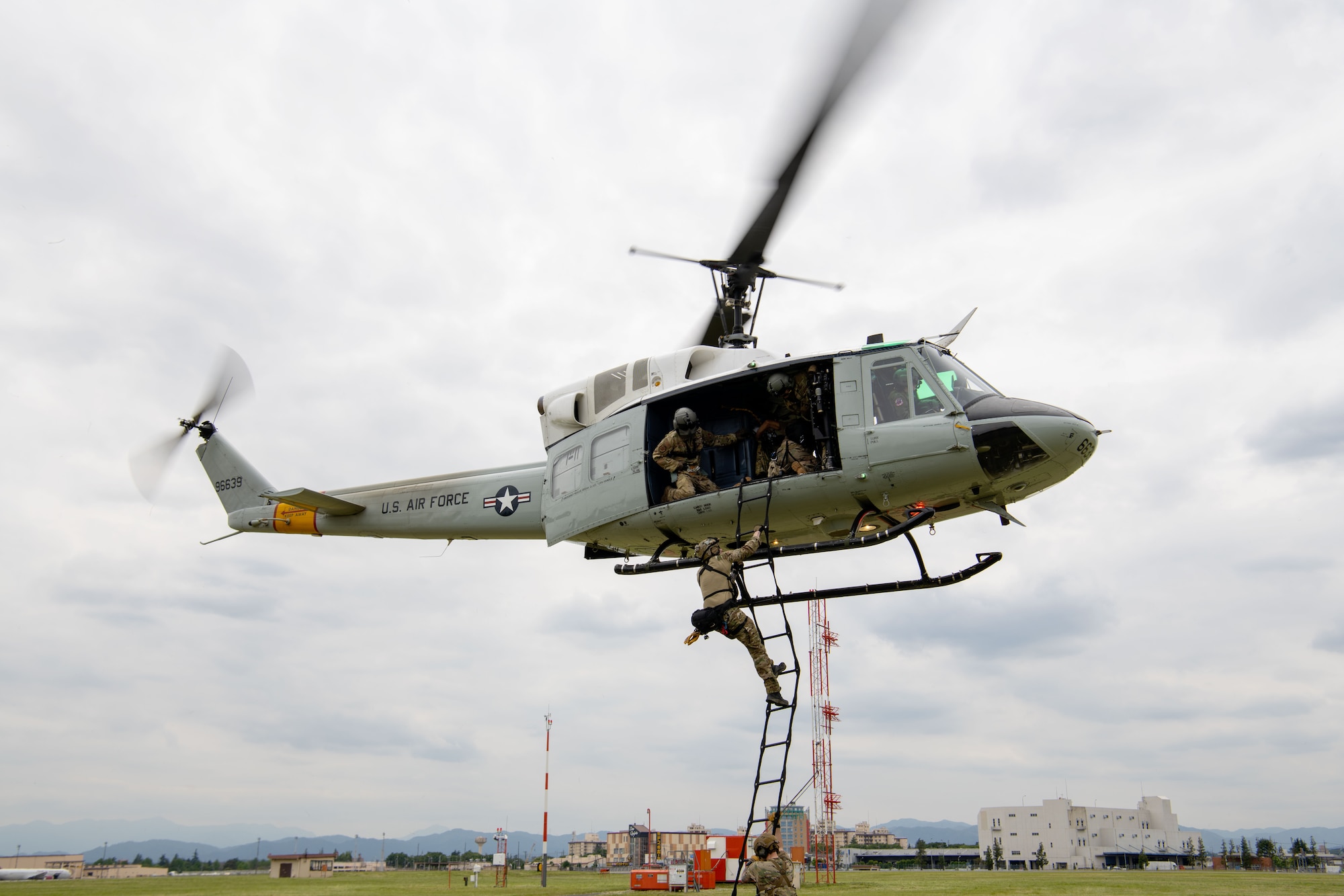 An Airman from the 320th Special Tactics Squadron, climbs a ladder on a UH-1N Iroquois helicopter