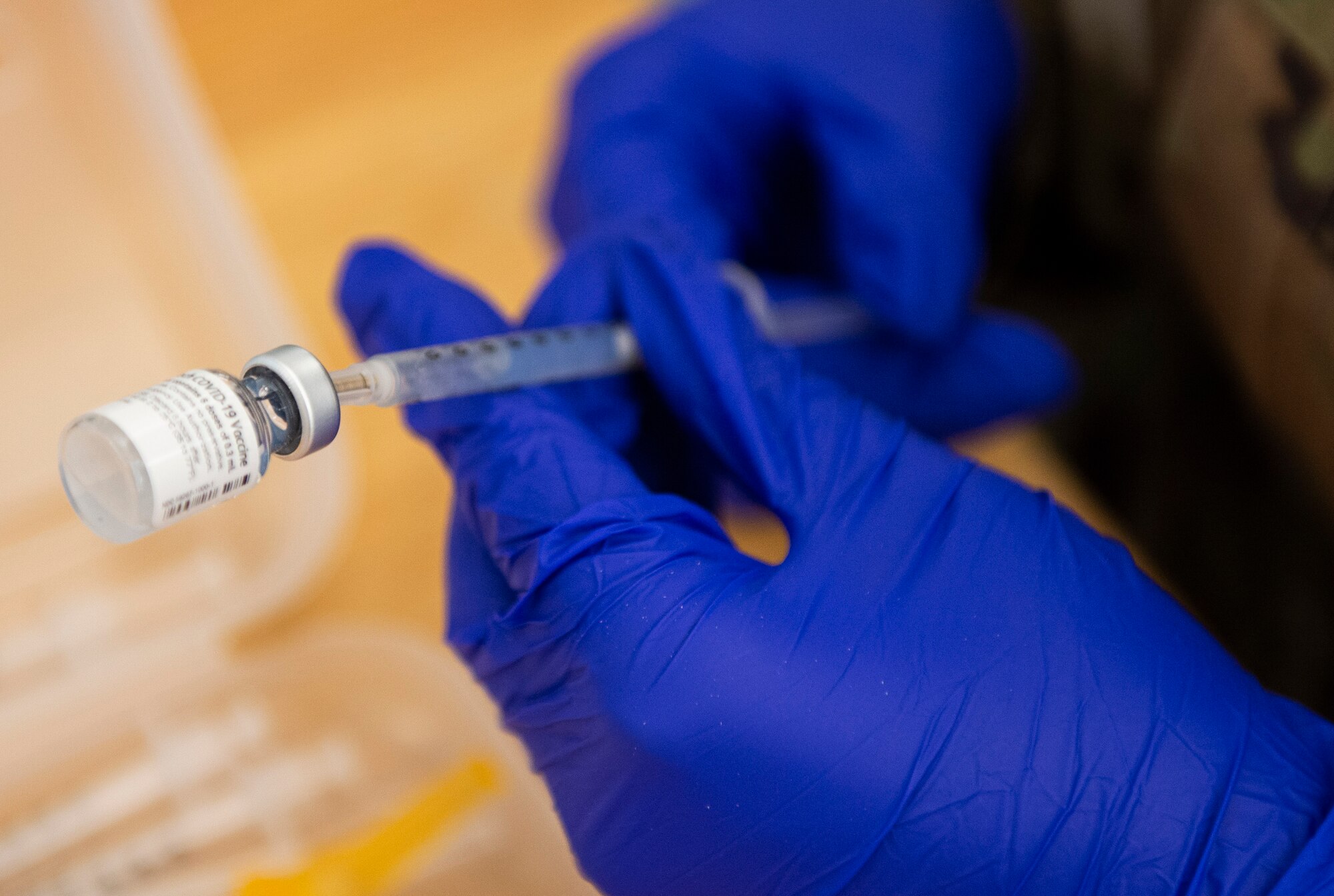 U.S. Air Force Senior Airman Aimee Fernandez, a medical logistics technician with the 88th Medical Group, Wright-Patterson Air Force Base, Ohio, fills a syringe with the COVID-19 vaccine inside the pharmacy area of the federally-supported Community Vaccination Center (CVC) at Ford Field in Detroit, Michigan, May 3, 2021. The Ford Field CVC is designed to vaccinate up to 6,000 community members per day. U.S. Northern Command, through U.S. Army North, remains committed to providing continued, flexible Department of Defense support to the Federal Emergency Management Agency as part of the whole-of-government response to COVID-19. (U.S. Air Force photo by Wesley Farnsworth)