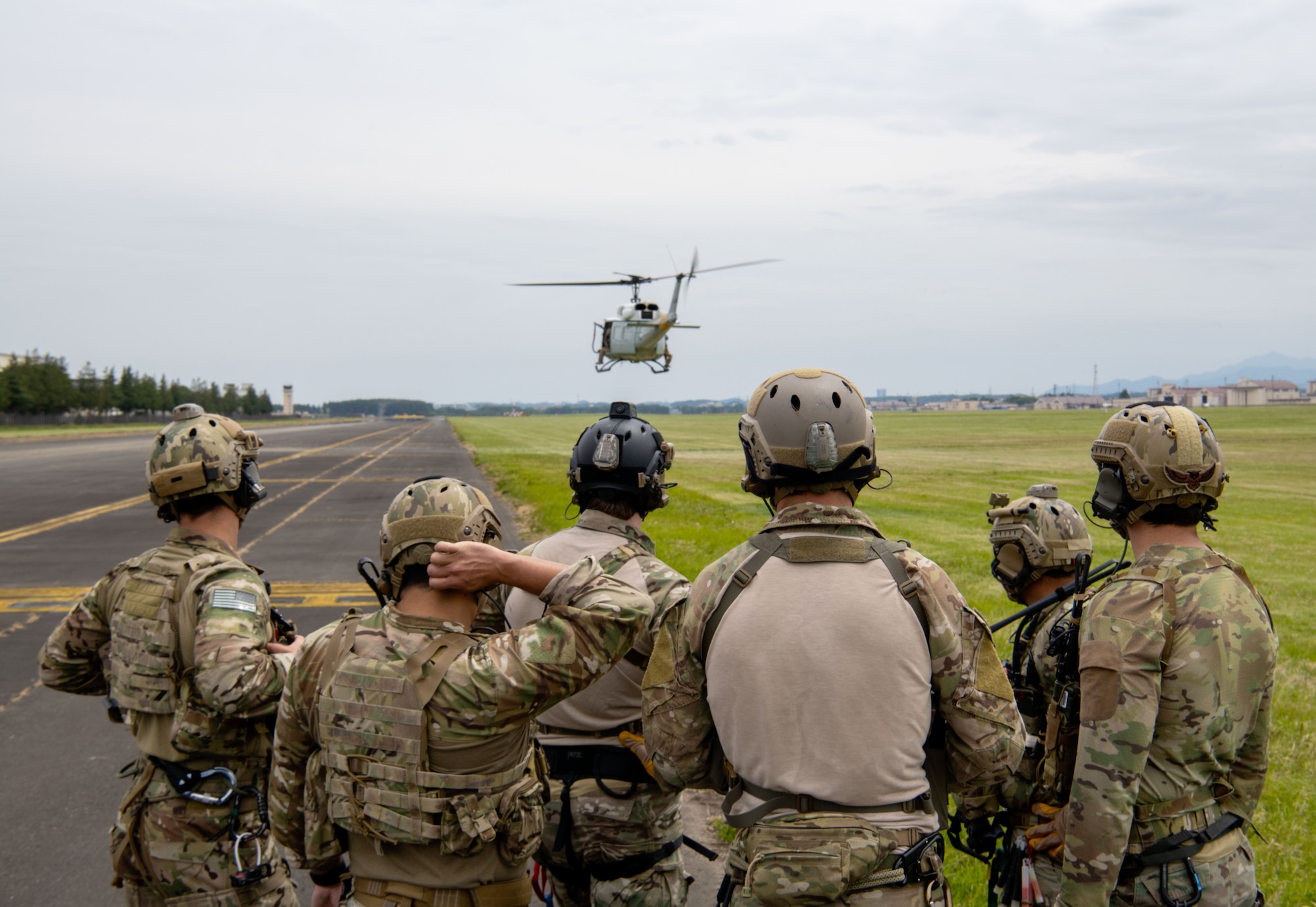 U.S. Air Force Airmen watch as helicopter hovers