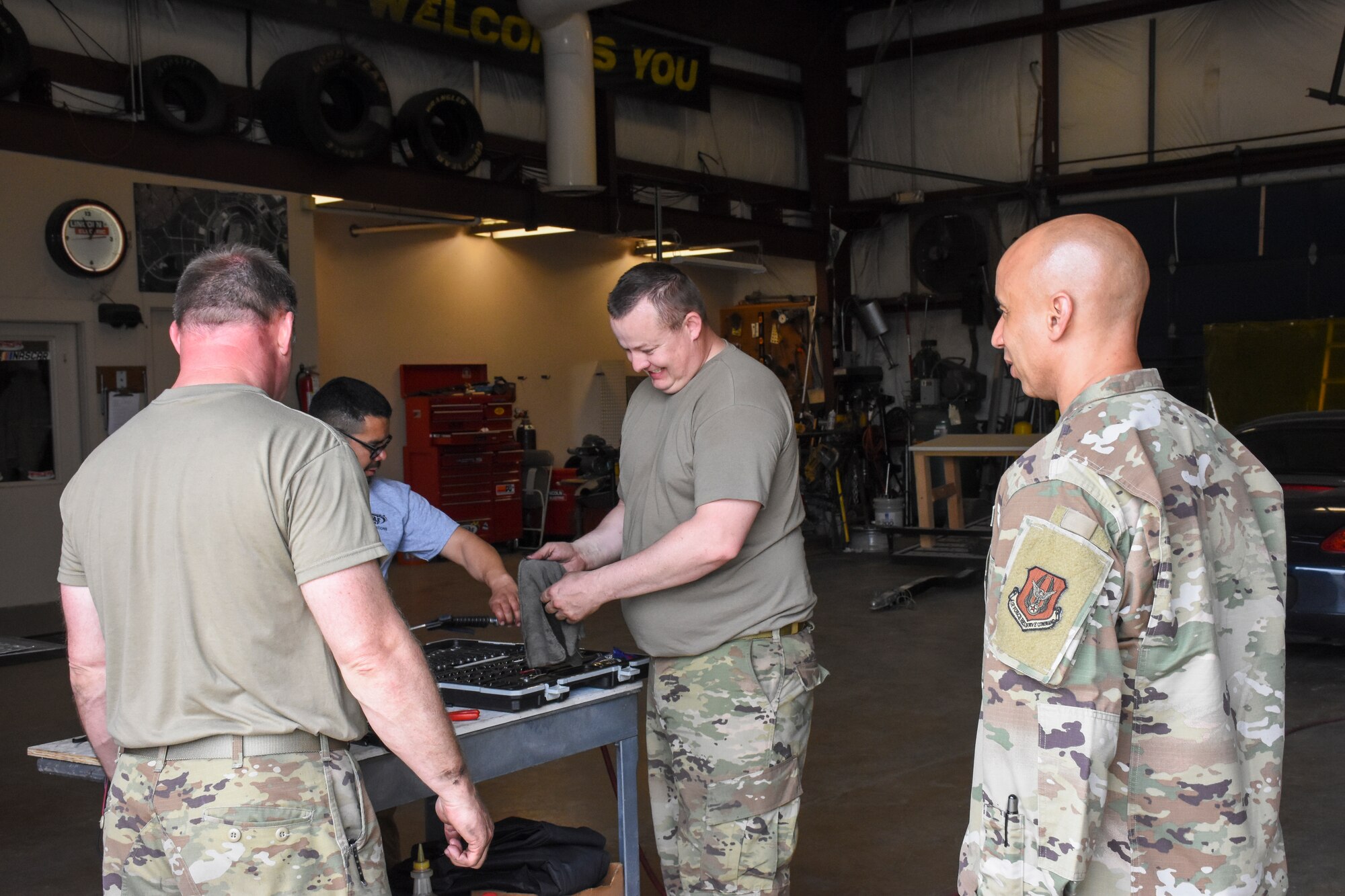 U.S. Air Force Tech. Sgt’s Boyd Kempher and Daniel Russell, both Aerospace and Jet Engine Propulsion mechanics show Chief Master Sgt. Earl Dundas, 442d Fighter Wing Interim Command Chief, the malfunctioning parts to the jet engine dryer at Kansas Speedway on 2 May 2021.