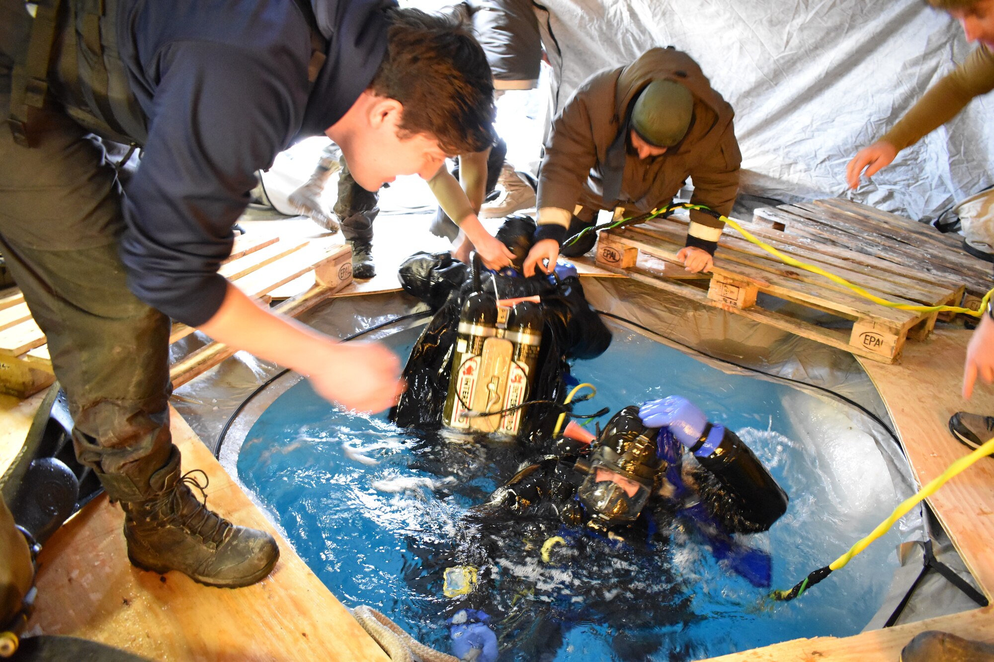 men diving under ice