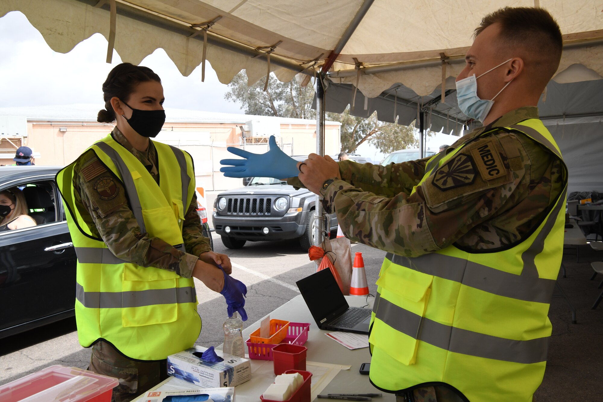Reserve Airman Senior Airman Danielle Ippolito, 944th Medical Squadron nurse, and Army Guard Specialist Karston Gardner, Combat Medic, 856th Military Police Company, prepare to administer COVID-19 shots to Salt River Pima-Maricopa Indian Community residents at the Salt-River Point of Dispensing site, March 26, 2021. As part of the Arizona National Guard Task Force Medical, servicemembers are augmenting vaccination sites for communities with low staffing and a high demand.