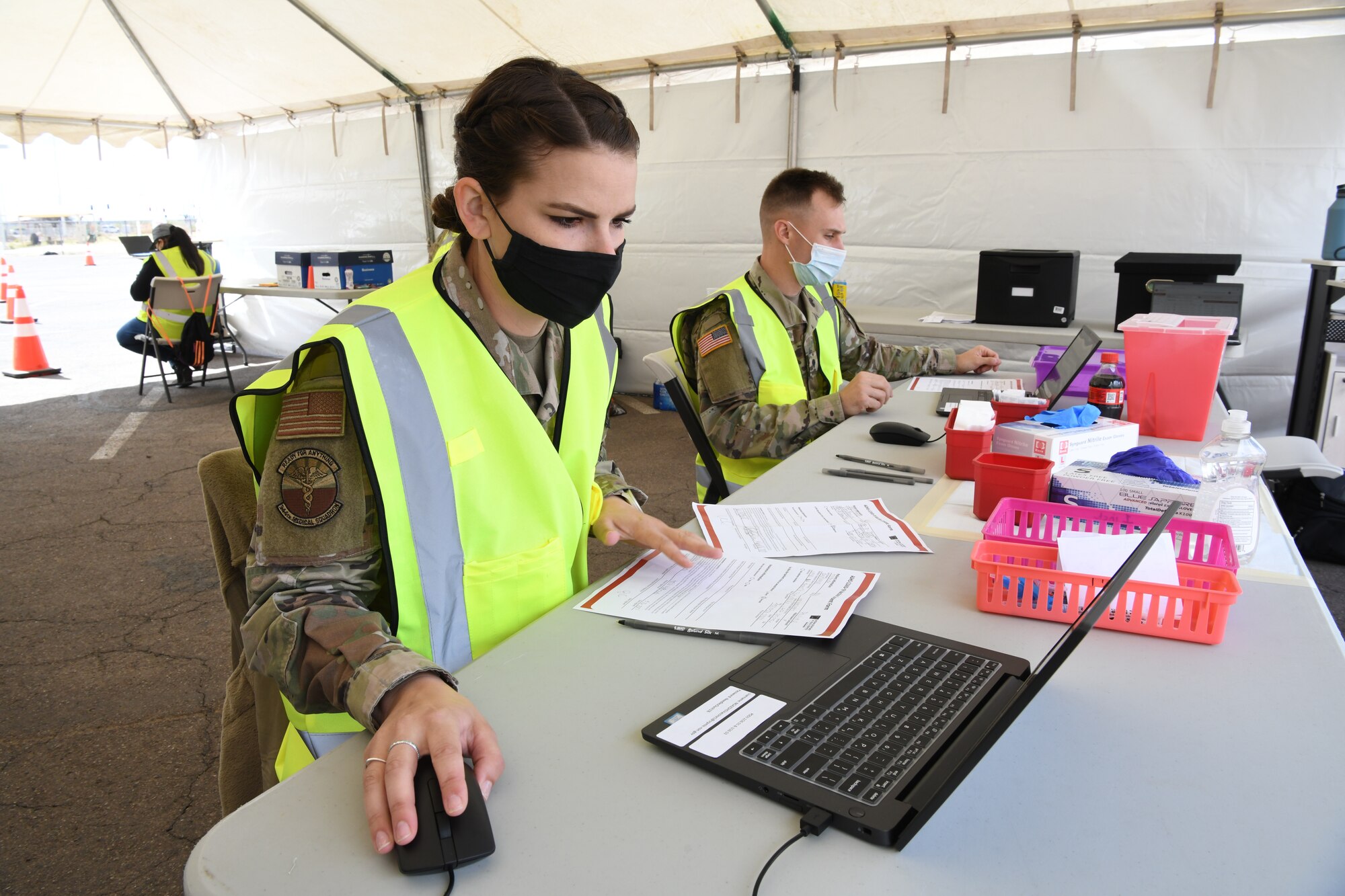 Reserve Airman Senior Airman Danielle Ippolito, 944th Medical Squadron nurse, and Army Guard Specialist Karston Gardner, Combat Medic, 856th Military Police Company, input information into the COVID-19 tracker for the Salt River Pima-Maricopa Indian Community residents they have vaccinated at the Salt-River Point of Dispensing site, March 26, 2021. As part of the Arizona National Guard Task Force Medical, servicemembers are augmenting vaccination sites for communities with low staffing and a high demand.