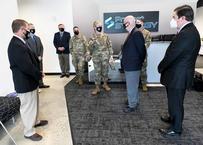 Photo shows group standing inside the entrance to Project Synergy.