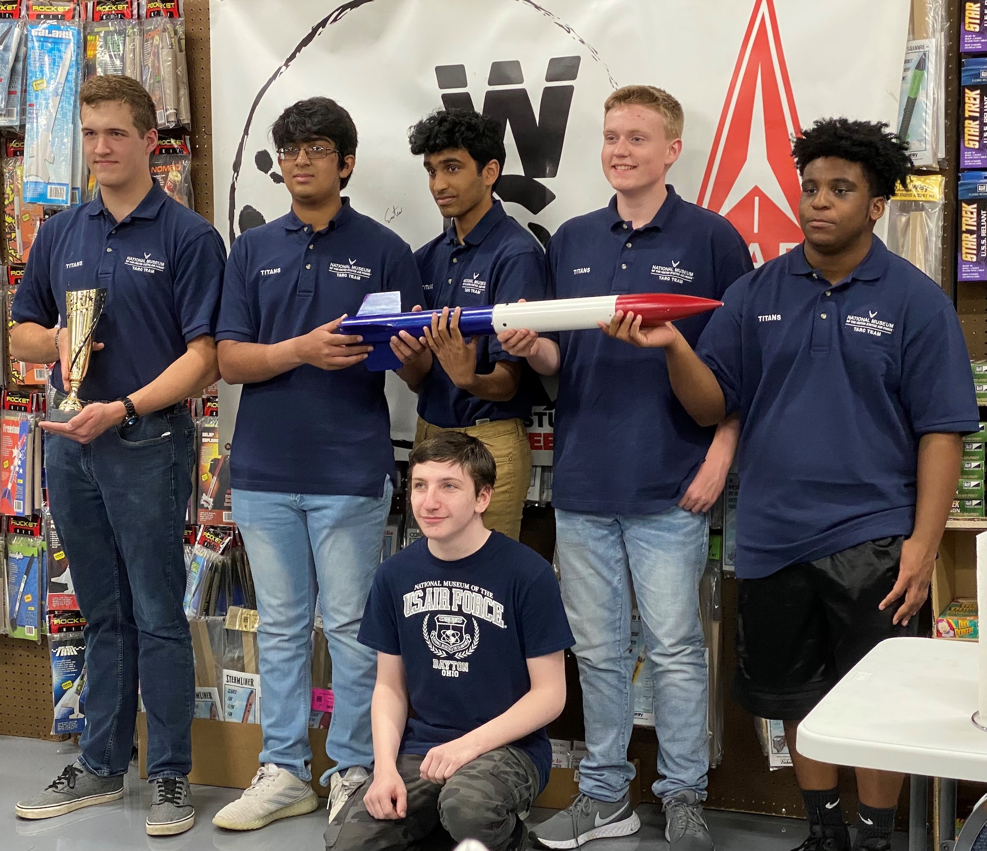 Picture of six young men holding a model rocket and a trophy