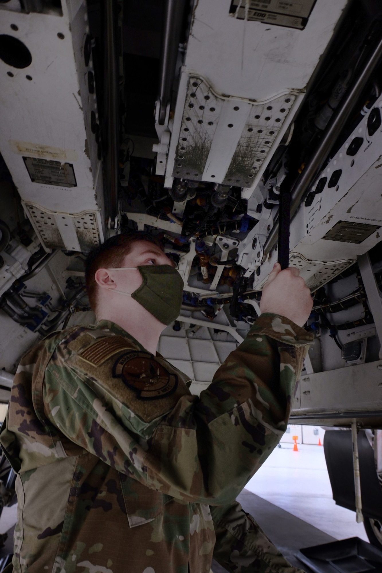 Air Force Airman 1srt Class Andrew Mathews, 3rd Aircraft Maintenance Squadron weapons load crew member, use a spanner wrench to lock an LAU-142/A Advanced Medium-Range Air-to-Air Missile Vertical Ejection Launcher on an F-22 Raptor at Joint Base Elmendorf-Richardson, Alaska, May 5, 2021. Mathews helped fabricate the spanner wrench, saving auxiliary power unit run time, wear, and tear.