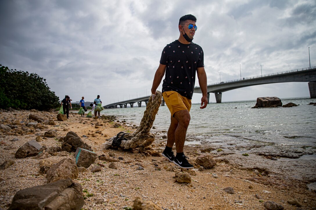 U.S. Marine Corps Cpl. Eric Valdez, an automotive maintenance technician with 3d Maintenance Battalion, 3d Marine Logistics Group, drags a rope to be discarded properly at the Earth Day cleanup on Kaa-Mii-Jii, Okinawa, Japan, May 7, 2021. Hosted by the Single Marine Program, weekly cleanups allow service members the opportunity to maintain cleanliness on and off base, and to help strengthen the U.S.-Japan alliance to protect the force and keep the Okinawan environment clean. The cleanup, postponed twice due to inclement weather, was hosted to raise awareness for Earth Day. Valdez is a native of Miami, Florida. (U.S. Marine Corps photo by Lance Cpl. Alex Fairchild)