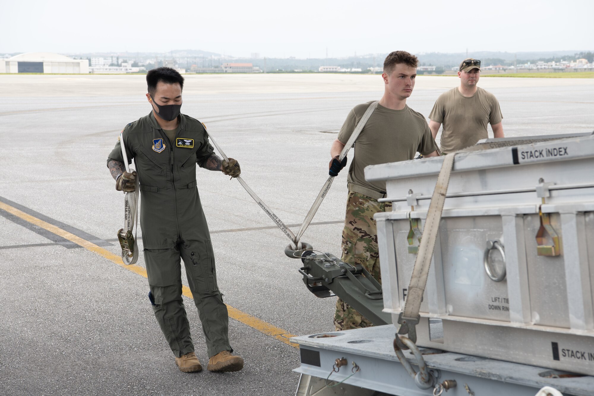 Airmen lifting munitions crate into aircraft