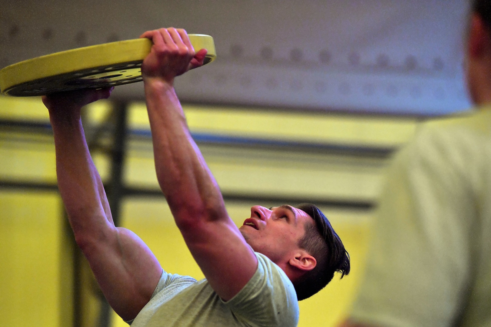 Member completes an overhead press with a 35 pound weight