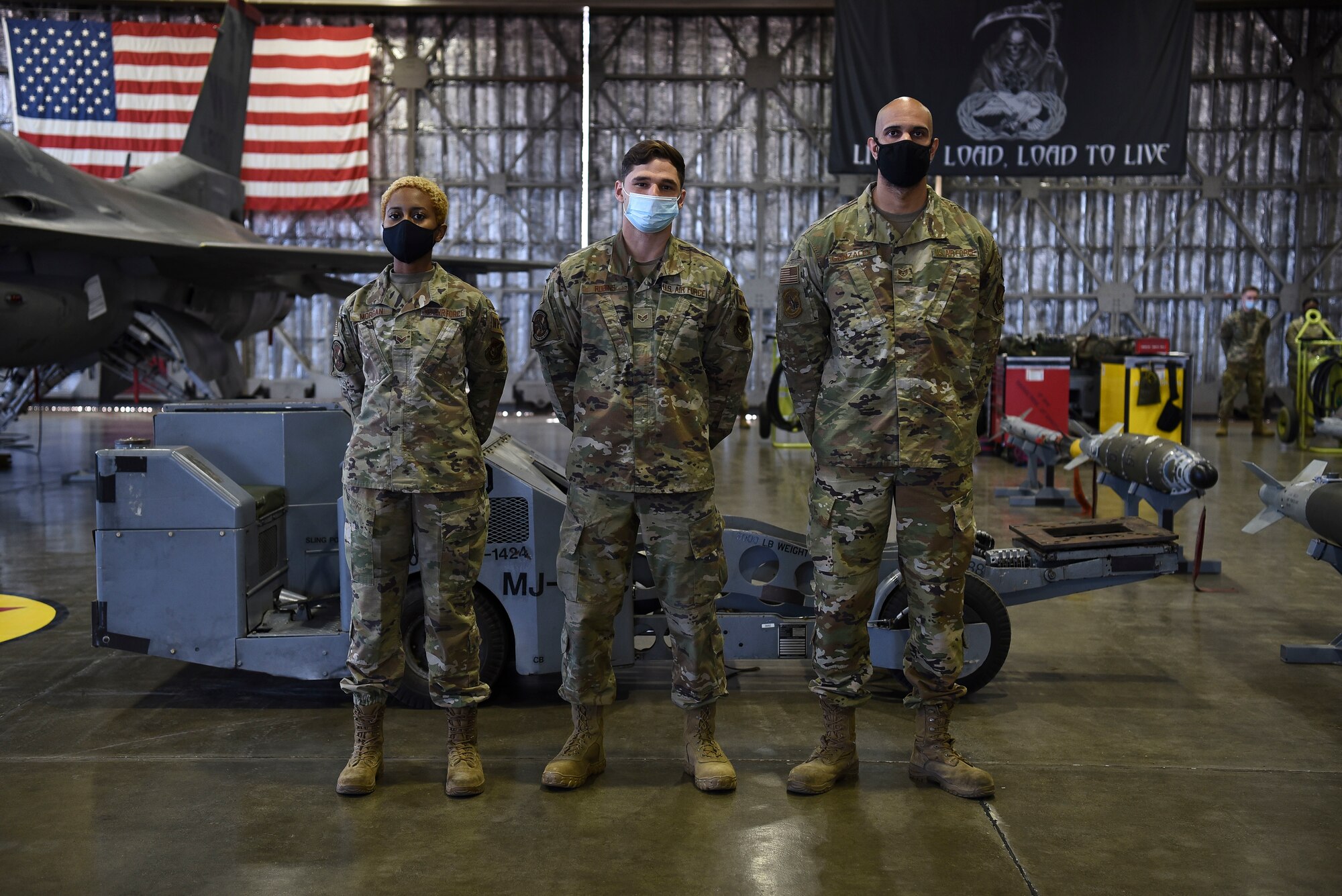 U.S. Air Force Senior Airman JoAnn Morgan, Senior Airman Ryan Robins and Staff Sgt. Jonathan Gonzales, 13th Aircraft Maintenance Unit personnel, stand in front of an F-16 Fighting Falcon prior to equipping weapons onto it during the first quarter load competition at Misawa Air Base, Japan, April 23, 2021.