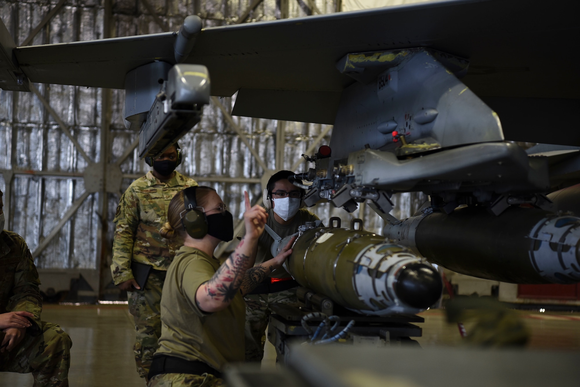 U.S. Air Force Staff Sgt. Kayla Faragher, and Senior Airman Victor Odom, 14th Aircraft Maintenance Unit personnel, align ammunition to attach it onto an F-16 Fighting Falcon during the first quarter load competition at Misawa Air Base, April 23, 2021.
