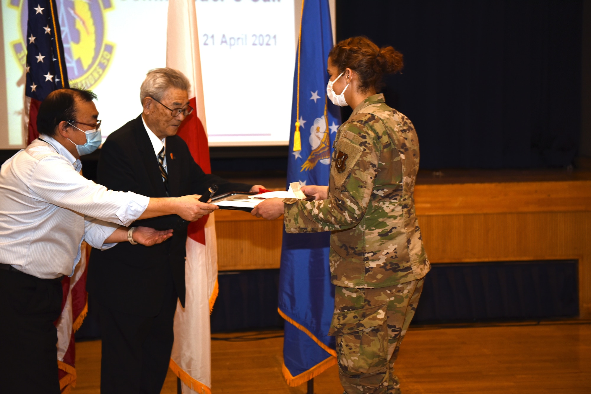 City of Misawa Social Welfare President, Shinji Kuroda, awards U.S. Air Force Senior Airman Hannah Tatum, 35th Communication Squadron radio frequency transmission systems technician, a letter of appreciation during an all-call at Misawa Air Base, April 21, 2021.