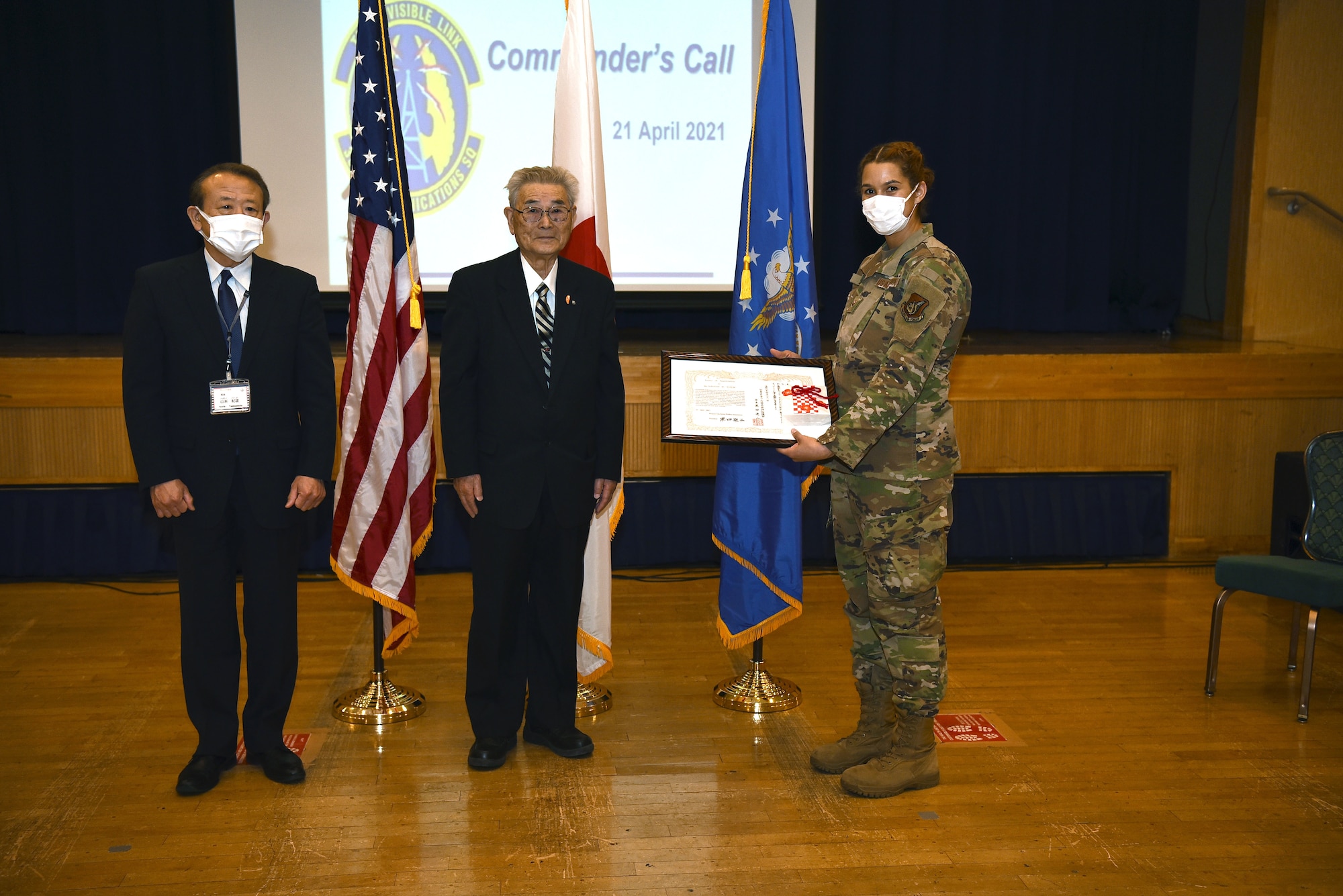City of Misawa officials, Director of Okamisawa “Jido-kan”, or after school program, Norio Yamamoto and Social Welfare President, Shinji Kuroda, present a letter of appreciation to U.S. Air Force Senior Airman Hannah Tatum, 35th Communication Squadron radio frequency transmission systems technician, during an all-call on Misawa Air Base, April 21, 2021.