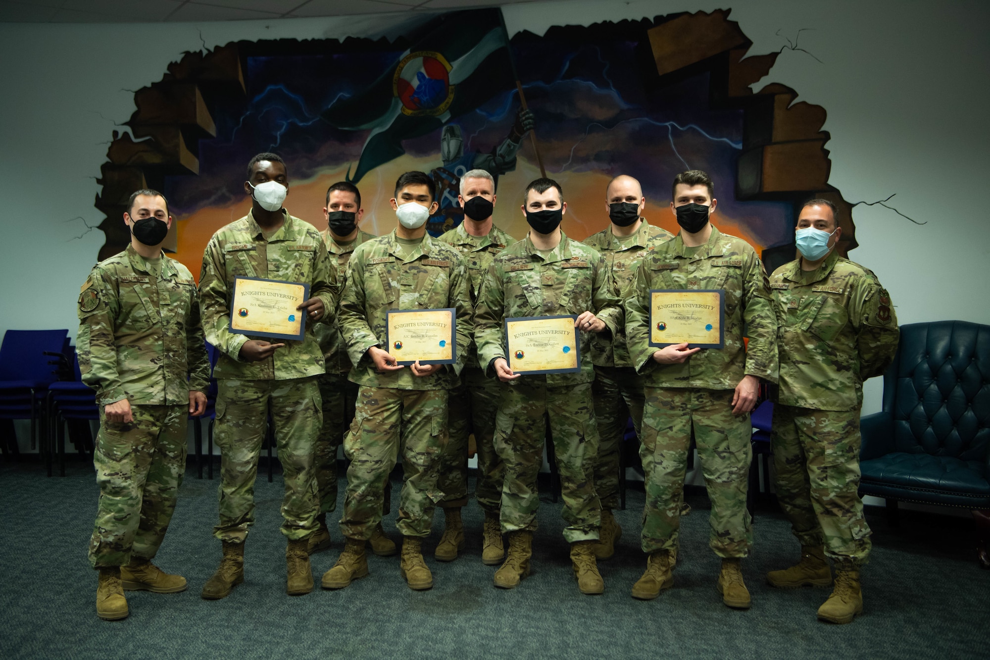 Airmen hold graduation certificates