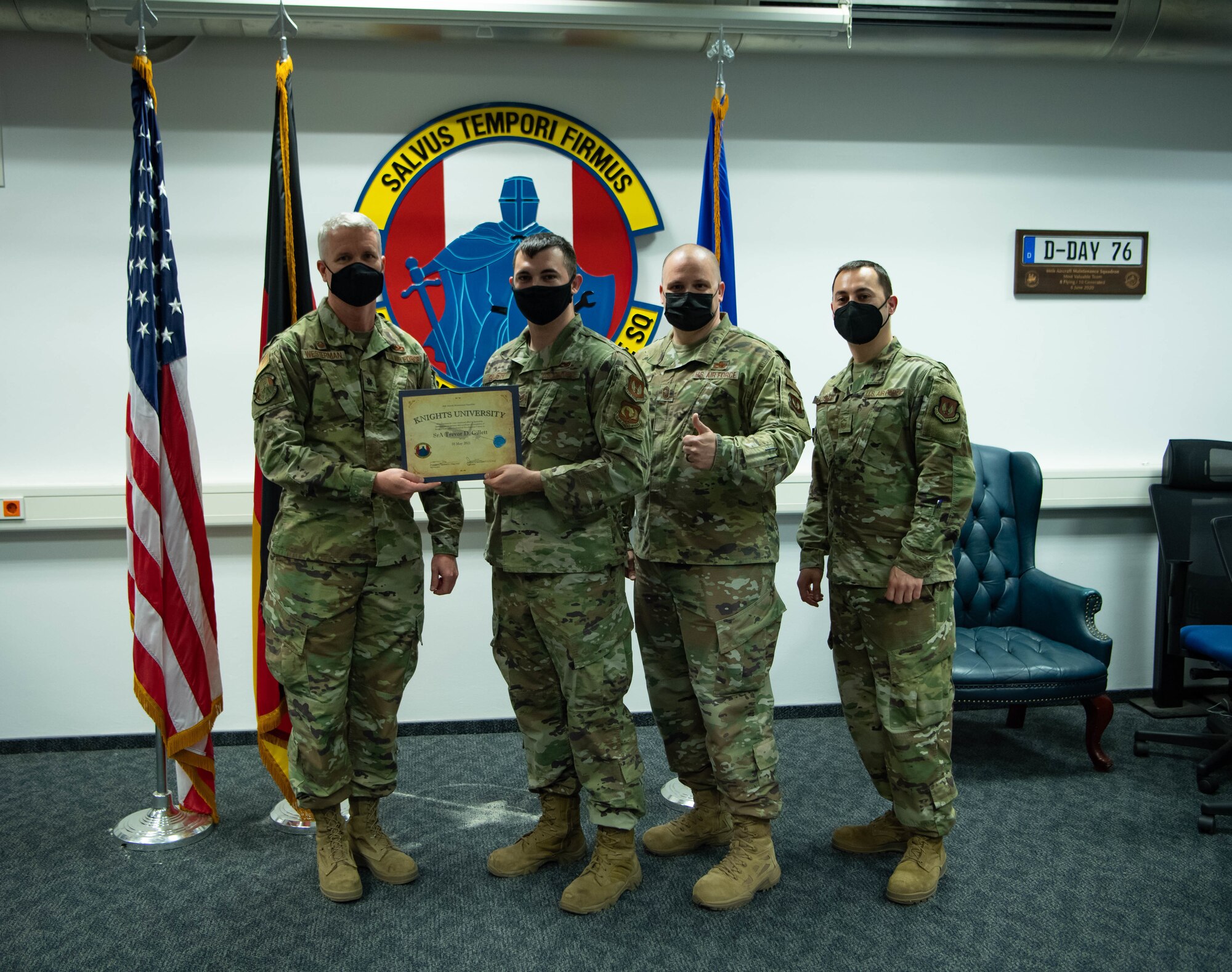 Airmen hold graduation certificates