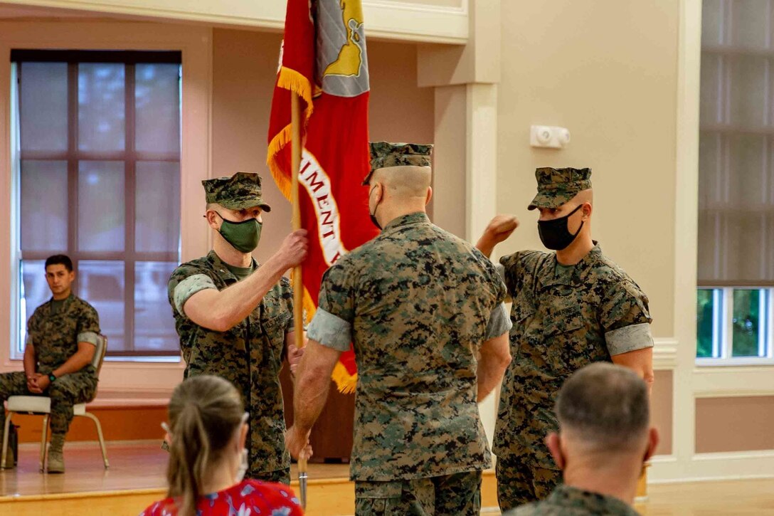 U.S. Marine Corps Col. Steven M. Sutey, left, the incoming commanding officer, receives colors from Col. Brian P. Coyne,  the outgoing commanding officer of 2d Marine Regiment (2d Marines), 2d Marine Division, during a change of command ceremony on Camp Lejeune, N.C., May 12, 2021.
