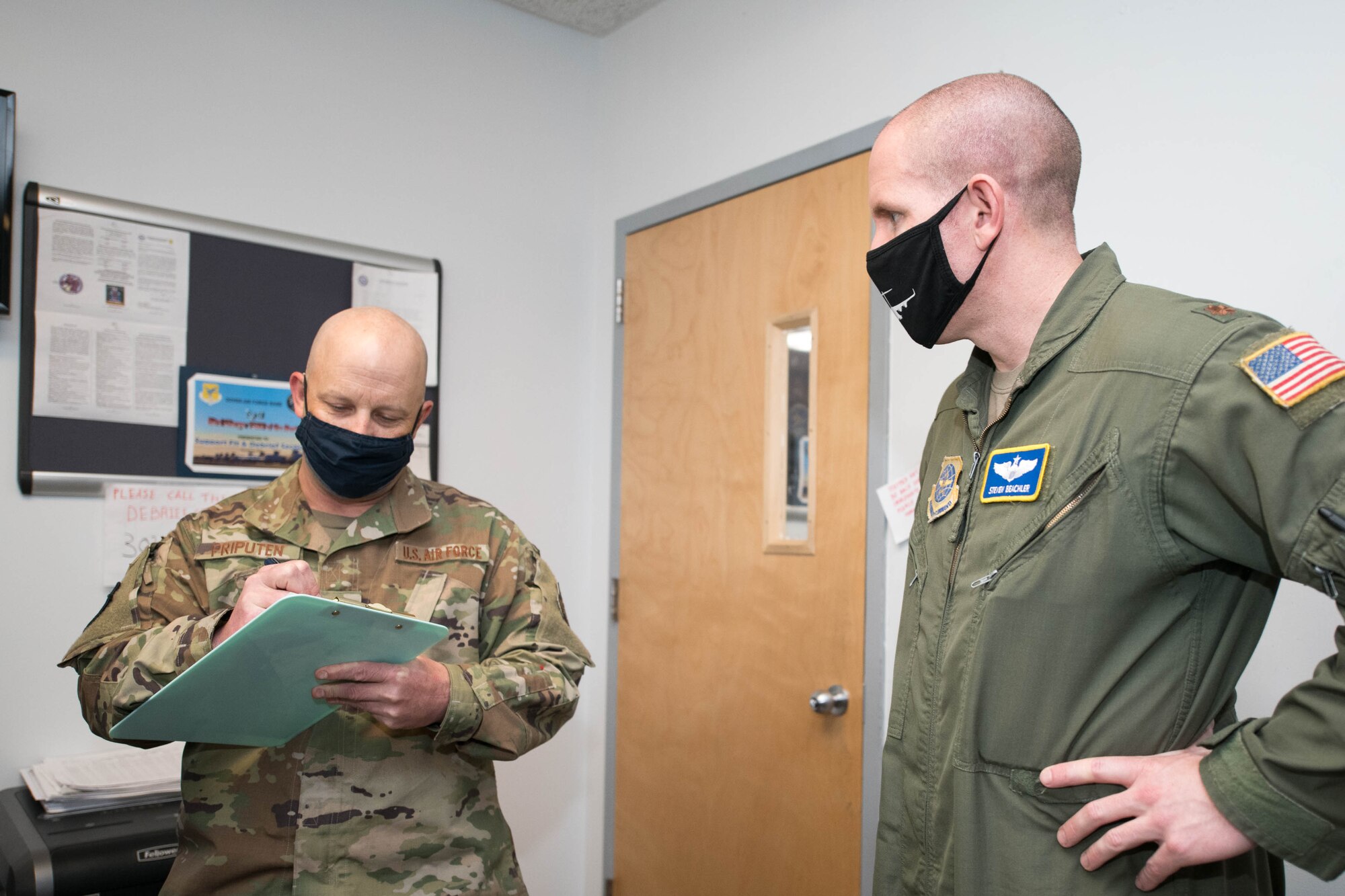Master Sgt. Scott Priputen, 736th Aircraft Maintenance Squadron production superintendent, and Maj. Steven Beachler, 3rd Airlift Squadron director of operations, complete a flight debrief at Dover Air Force Base, Delaware, May 13, 2021. The Mattermost app has helped streamline the debrief process, saving an average of two hours each instance. (U.S. Air Force photo by Mauricio Campino)