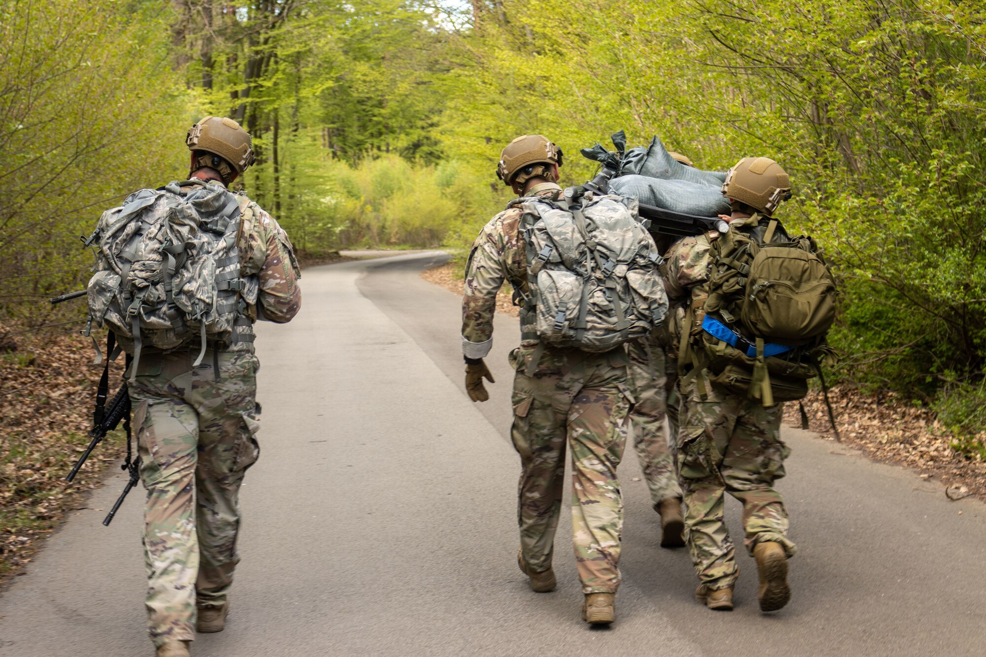 U.S. Air Force law enforcement personnel assigned to the Kaiserslautern Military Community carry a cot filled with sandbags during a ruck march for National Police Week at Pulaski Barracks, Germany
