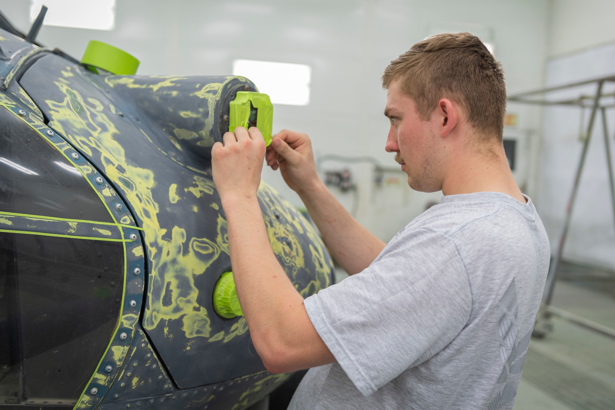 Photo of an Airman masking a helicopter