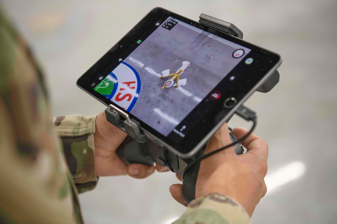 A service member operates a hand-held electronic device.