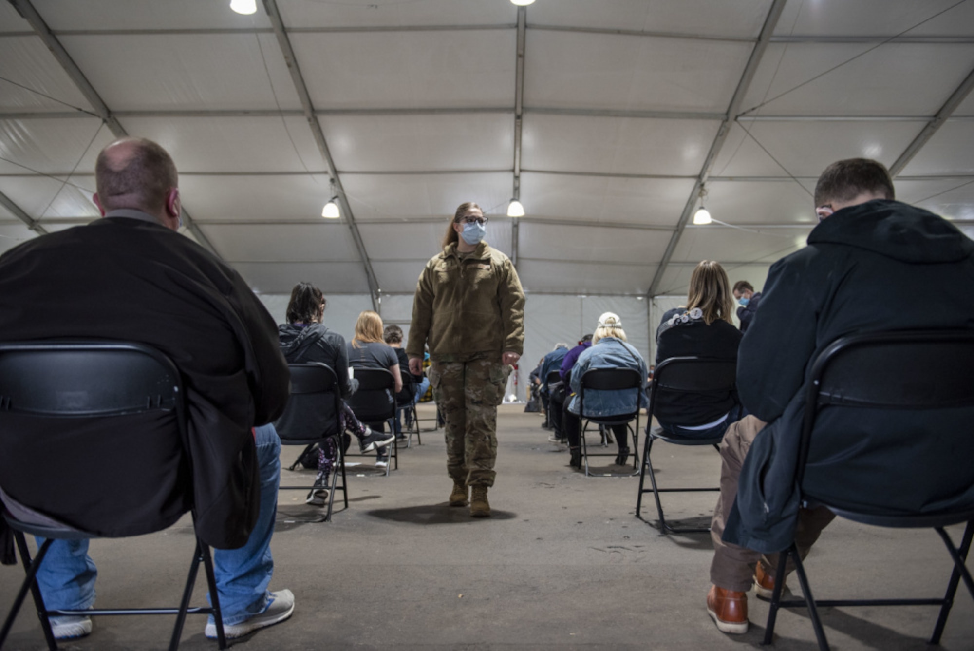 U.S. Air Force Staff Sgt. Tristan Crosswhite, assigned to the 92nd Operational Medical Readiness Squadron at Fairchild Air Force Base, Washington, observes local community members after receiving their COVID-19 vaccination at the Community Vaccination Center (CVC) at the Minnesota State Fairgrounds in St. Paul, Minnesota, April 23, 2021. The CVC welcomes St. Paul community members to receive free COVID-19 vaccines. U.S. Northern Command, through U.S. Army North, remains committed to providing continued, flexible Department of Defense support to the Federal Emergency Management Agency as part of the whole-of-government response to COVID-19. (U.S. Air Force photo by Staff Sgt. Mikaley Kline)