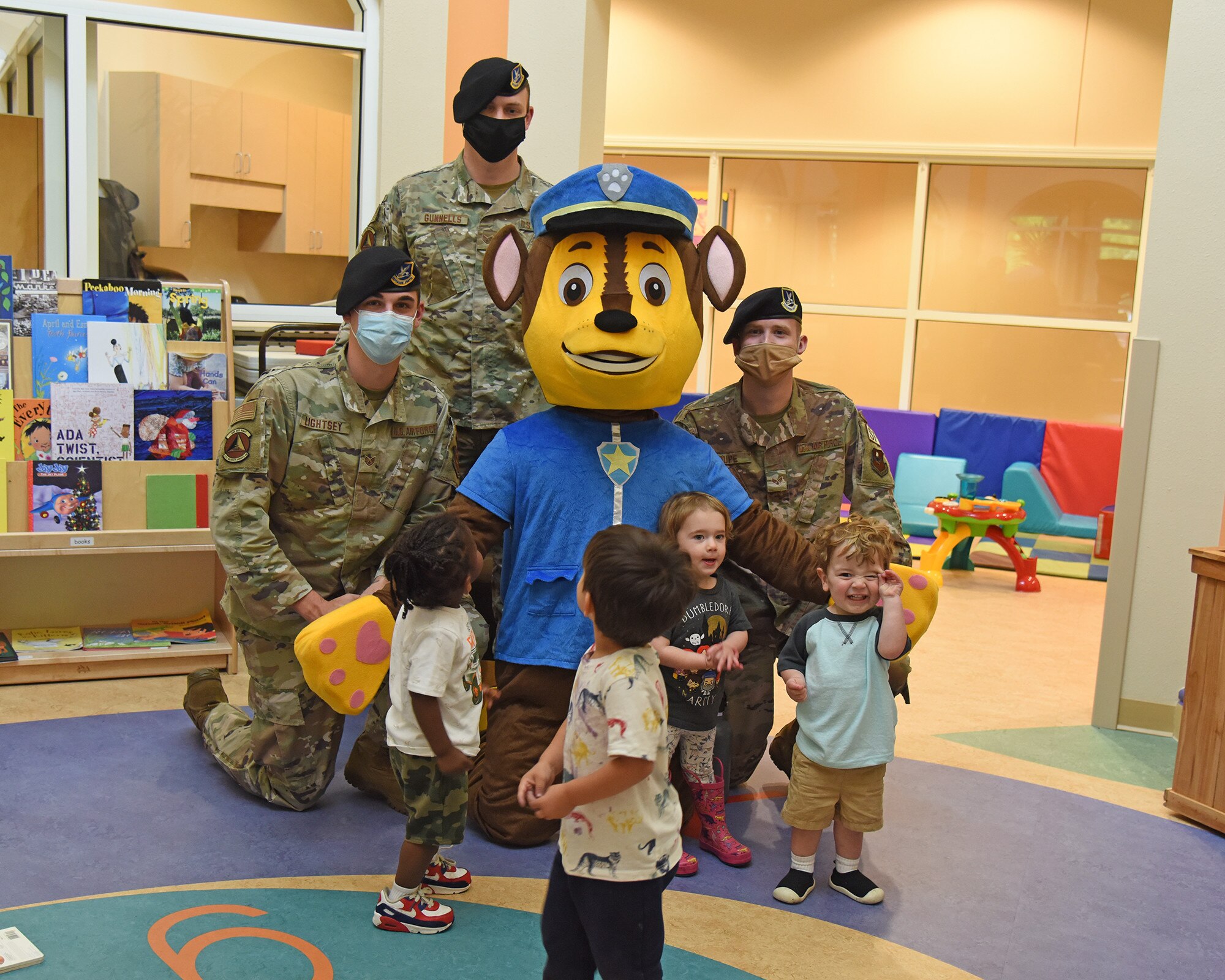 Members of the 14th Security Forces Squadron and their mascot, Chase the dog, pose for a photo with children at the Child Development Center, May 11, 2021, on Columbus Air Force Base, Mississippi. Columbus AFB had several events to show appreciation to the 14th Security Forces Squadron for National Police Week. (U.S. Air Force photo by Elizabeth Owens)