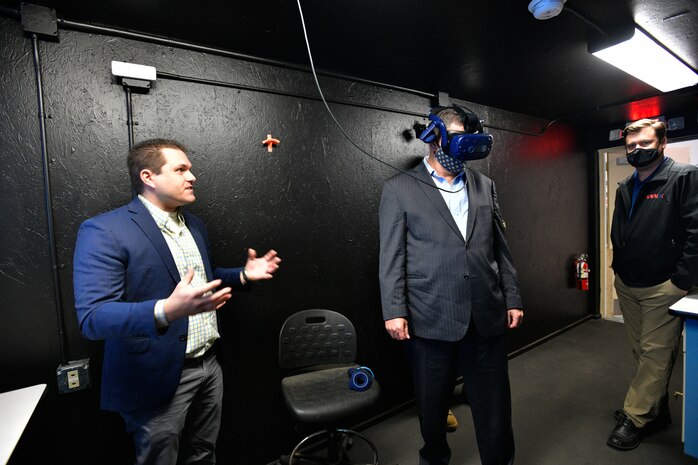 Left to right: Jason Bickford, research manager for Naval Surface Warfare Center, Port Hueneme Division (NSWC PHD), explains to The Honorable James F. Geurts, currently performing the duties of (PTDO) Under Secretary of the Navy (center), the capabilities of augmented reality as Geurts tries out the system at NSWC PHD’s Fathomwerx Lab while socially distanced with the help of Alan Jaeger, NSWC PHD’s Office of Research and Technology Applications manager (right), during Geurts’ visit to the command May 7.