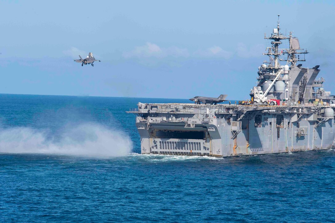 A jet prepares to land on a ship.