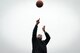 Civilian man throws basketball into air.