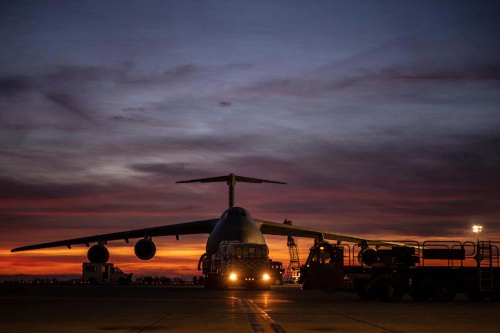 Airmen from the 60th Aerial Port Squadron load pallets holding lifesaving COVID-19 supplies onto a C-5M Super Galaxy at Travis Air Force Base, California, April 30, 2021.