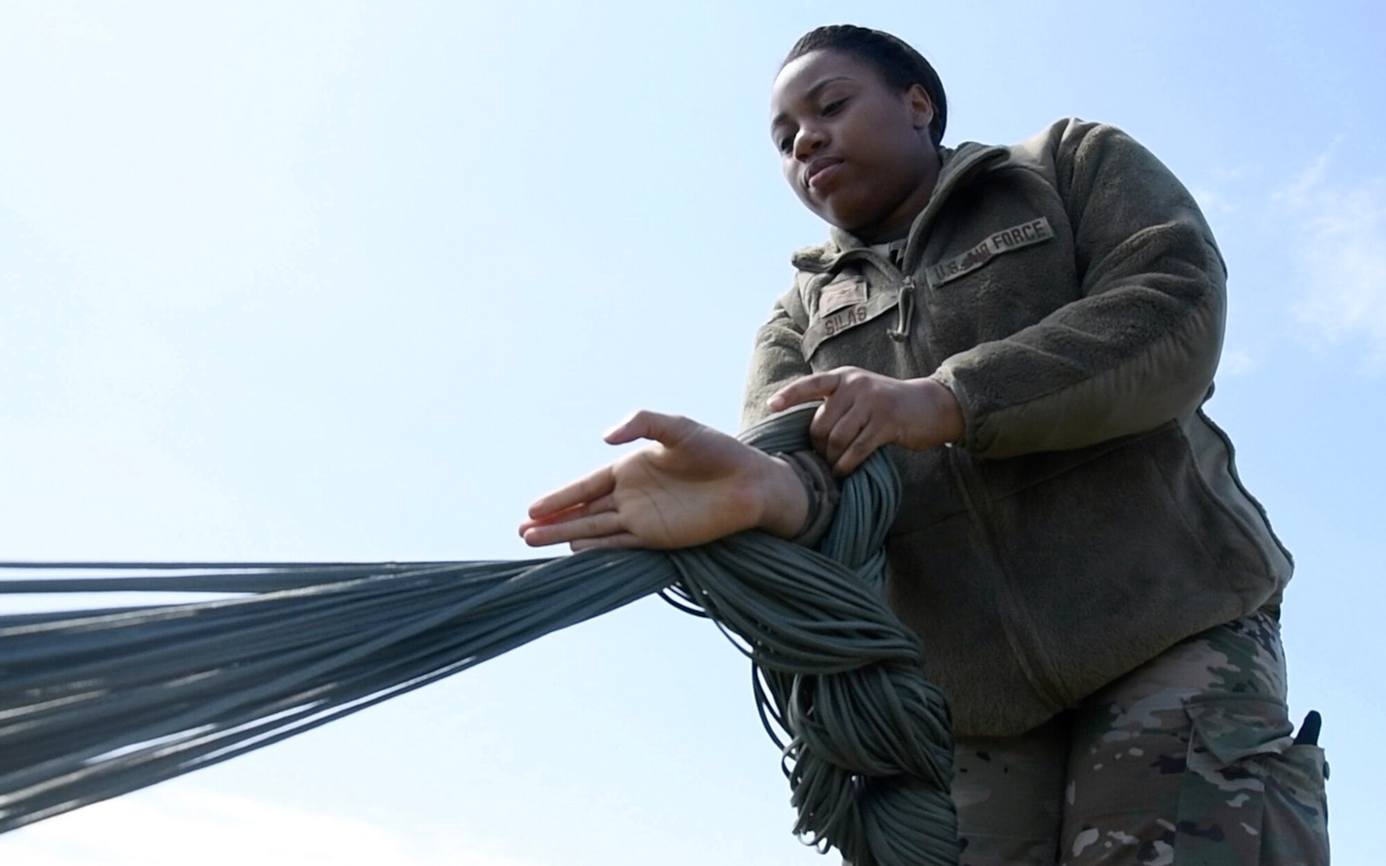 a woman daisy chaining parachute lines