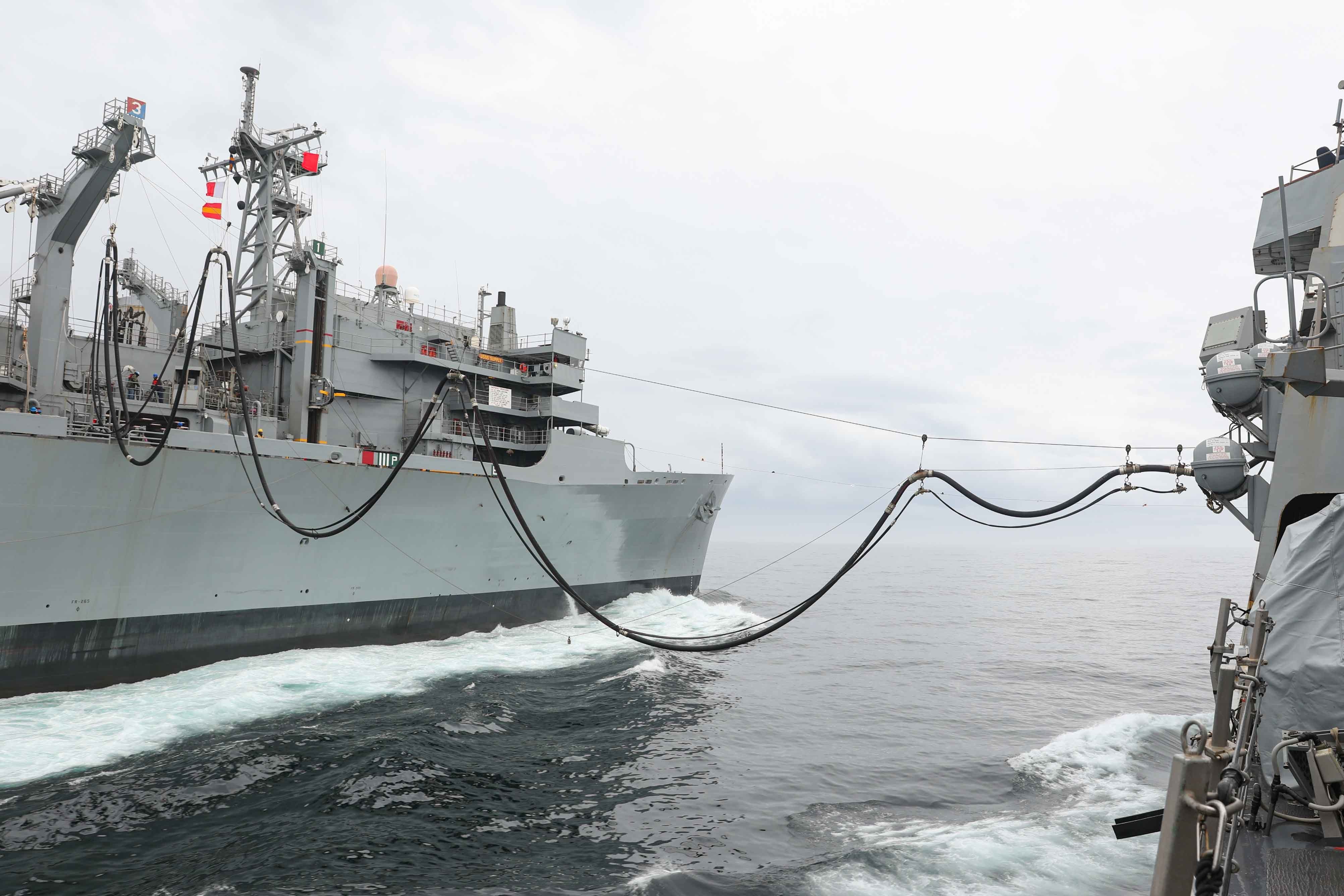 The Arleigh Burke-class guided-missile destroyer USS Ross (DDG 71), right, receives fuel during a replenishment-at-sea.