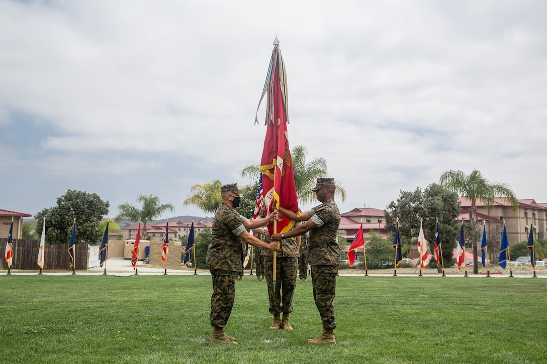 U.S. Marine Corps Col. Nick I. Brown, outgoing commanding officer, right, Combat Logistics Regiment 17, 1st Marine Logistics Group, and incoming commanding officer Col. John S. McCalmont, left, exchange the Regiment colors during the CLR-17 change of command ceremony at Marine Corps Base Camp Pendleton May 13, 2021. Since 1992, CLR-17 has provided command and control, administration, communications, food services, and services to the 1st MLG.