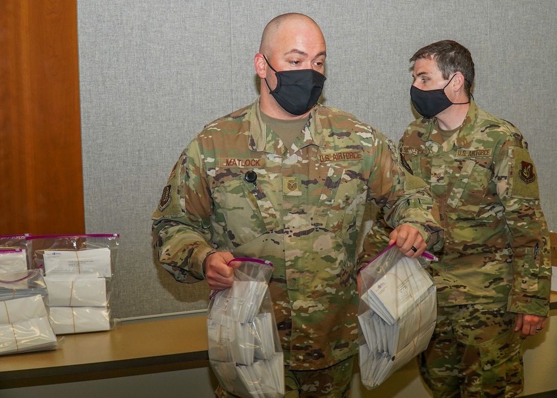 U.S. Air Force Tech. Sgt. John Matlock, the 673d Medical Group chief enlisted executive assistant, and U.S. Air Force Staff Sgt. Alex Shuttleworth, the 673d Operational Medical Readiness Squadron noncommissioned officer in charge of radiation element, hand out bone marrow registration envelopes to unit representatives at Joint Base Elmendorf-Richardson, Alaska, May 10, 2021. JBER is hosting a bone marrow registry drive May 17 to 28 to register JBER personnel through the C.W. Bill Young Department of Defense Bone Marrow Program.