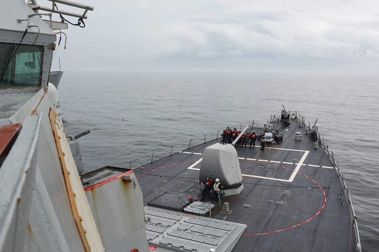 Sailors stationed aboard the Arleigh Burke-class guided-missile destroyer USS Ross (DDG 71) hold a phone and distance line during a replenishment-at-sea with the fast combat support ship USNS Supply (T-AOE 6), May 10, 2021.