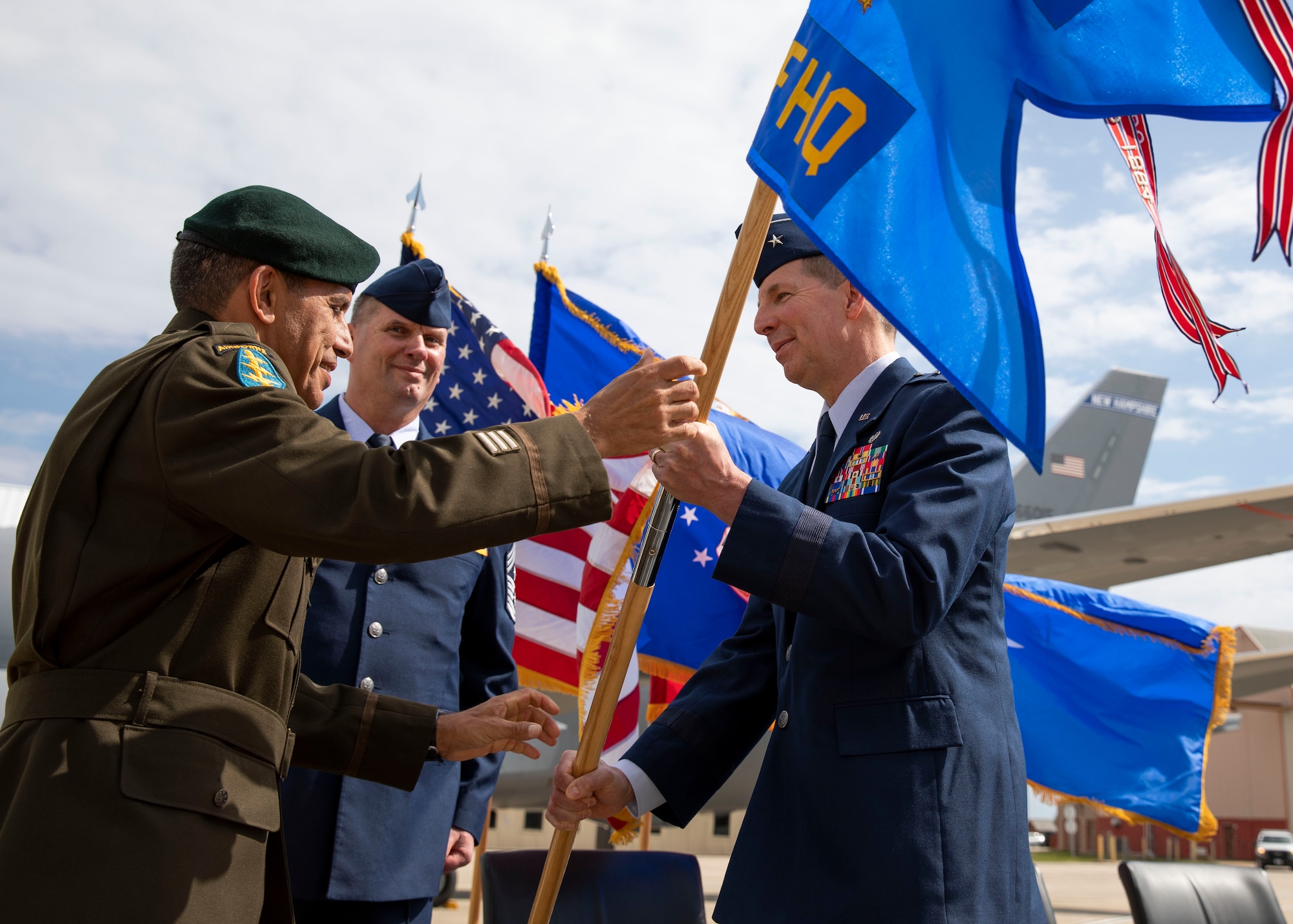 NH Adjutant Gen. David Mikolaities passes the organizational flag to incoming commander of the NH Air National Guard, Brig. Gen. Jed French, at a change of command ceremony May 15 at Pease Air National Guard Base. French assumed command from outgoing commander, Brig. Gen. Laurie Farris, who was then promoted to major general as assistant to the commander of Air Mobility Command at Scott Air Force Base, Ill.  Looking on is State Command Chief Master Sgt. John Symington. Photo by Staff Sgt. Charles Johnston, NHNG Deputy State PAO.