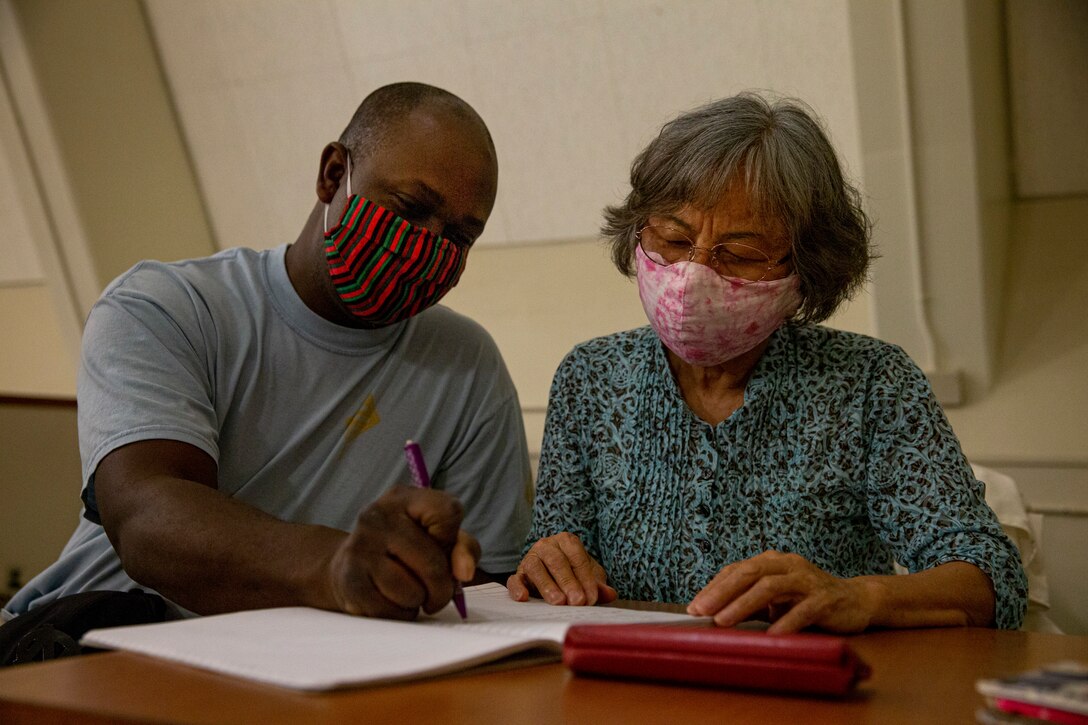 U.S. Navy Petty Officer 3rd Class Jonathan Sutton, a hospital corpsman with the operational stress control and readiness training team, 3d Marine Division, interacts with Toshiko Nakama, a Okinawa resident, during an English class at the Camp Hansen West Chapel on Camp Hansen, Okinawa, Japan, May 11, 2021. The English discussion provides U.S. Marines and Okinawa residents with an opportunity to come together, learn each other’s language and share their culture in an interactive classroom setting. The discussion is held every Tuesday at 7:30 p.m. at the Camp Hansen West Chapel. (U.S. Marine Corps photo by Lance Cpl. Alex Fairchild)